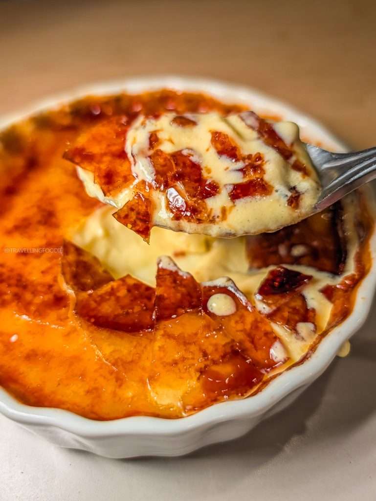 A spoonful of creamy Vanilla Creme Brulee with a thick caramelized sugar crust at Les Fougeres restaurant in Chelsea.