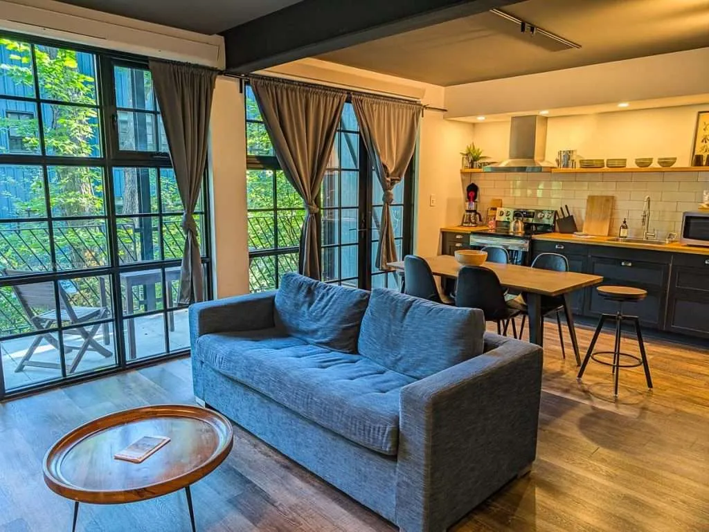 The spacious living room and fully-equipped kitchen inside a modern Large Loft at Lofts du Village in Chelsea Quebec.