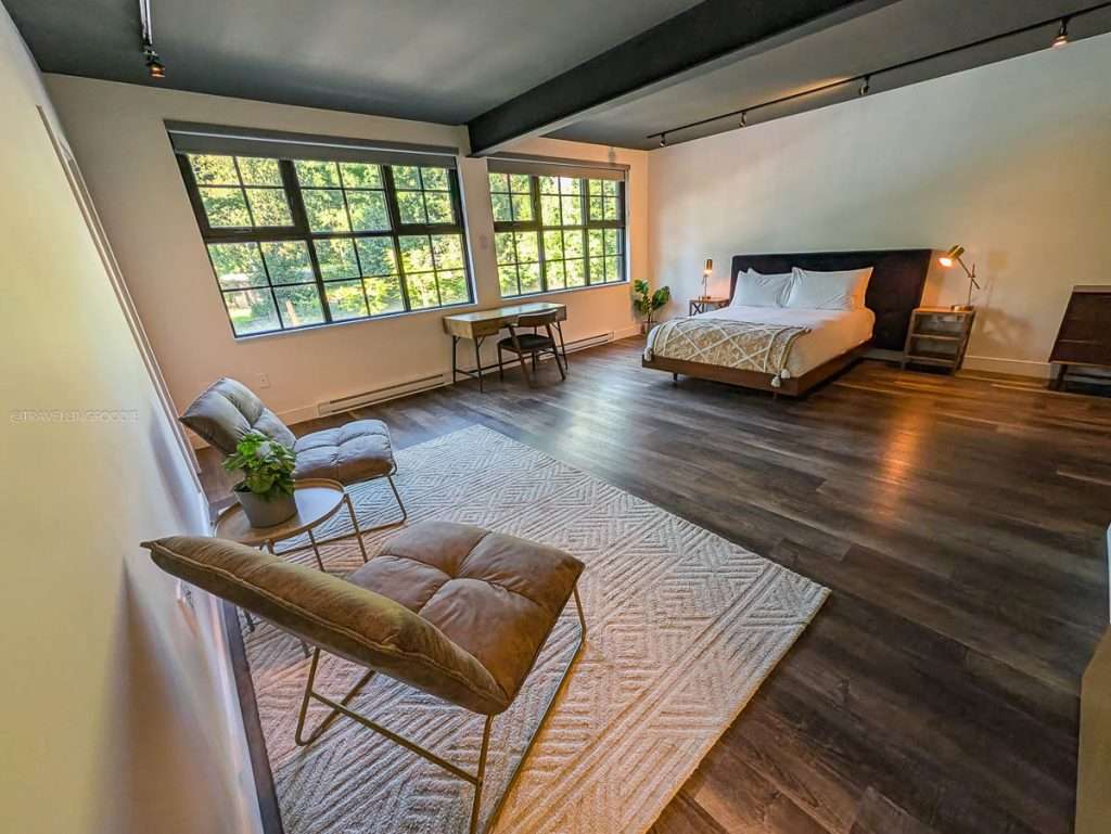 The massive open-plan bedroom and living area of a luxury boutique suite at Lofts du Village, a top Chelsea hotel.