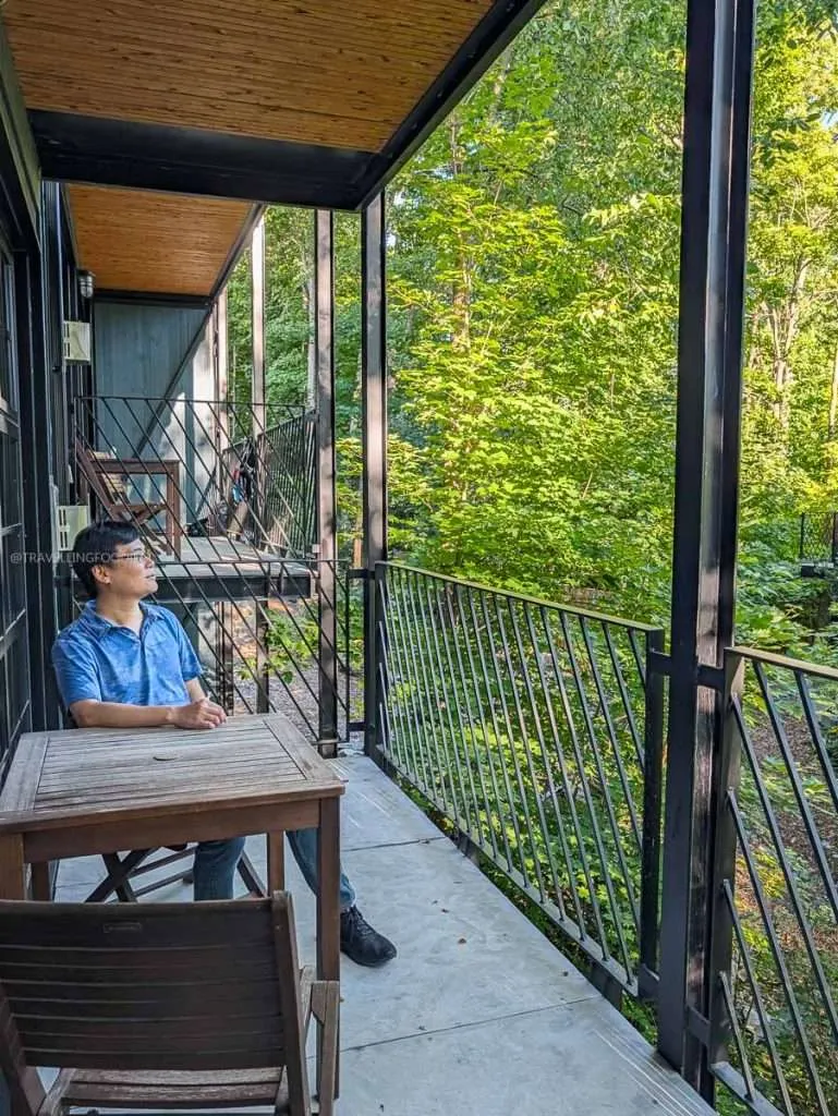 Raymond Cua relaxing on the private forest balcony of his Large Loft at Lofts du Village, where to stay in Chelsea.