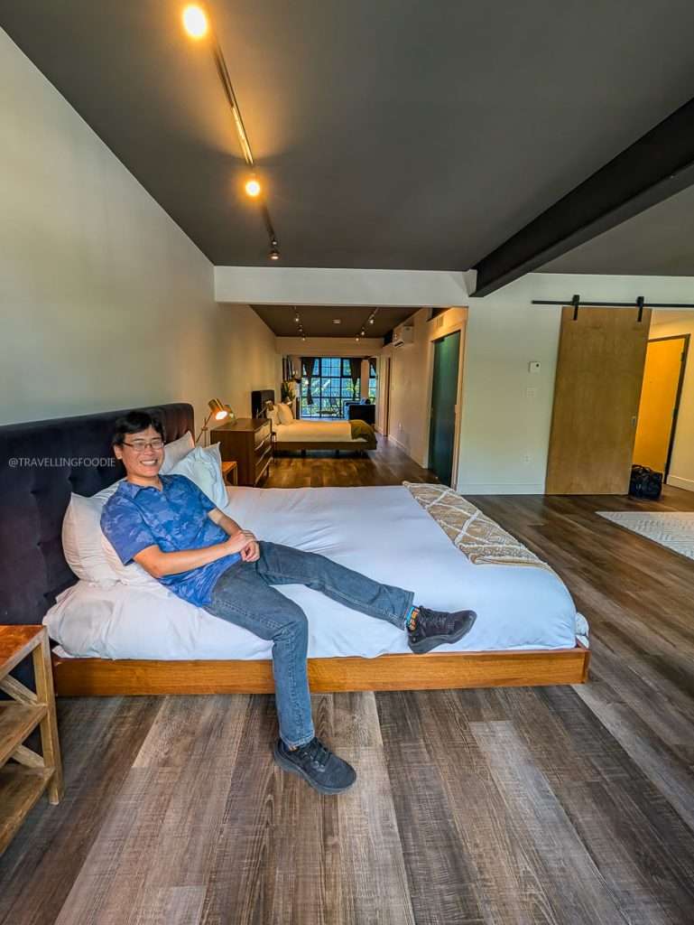 Raymond Cua relaxing on the bed inside the spacious Large Loft suite at Lofts du Village in Chelsea Quebec.
