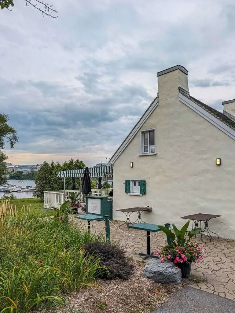Historic stone exterior and patio of Maison Charron riverside bistro in Jacques-Cartier Park, Gatineau Quebec.