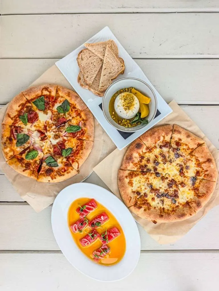 Wood-fired Enzo pizza, Carbonara pizza, burrata, and tuna carpaccio spread at Maison Charron in Gatineau Quebec.