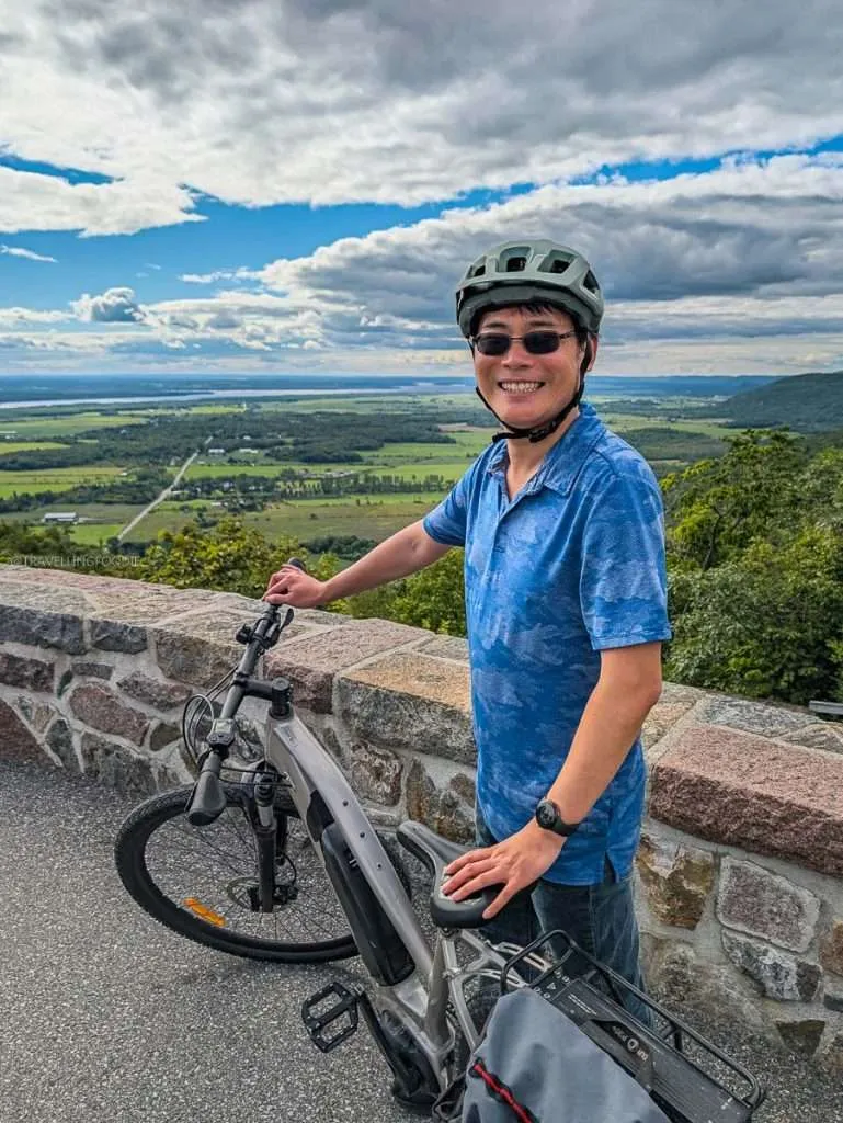 Raymond Cua posing with an electric bicycle at Champlain Lookout in Gatineau Park, Chelsea Quebec